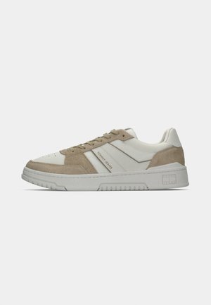 Sneakers met een bovenwerk van wit leer en beige suède, ronde neus, tonale veters en een gestructureerde grijze rubberen zool. 'TOMMY JEANS' branding zichtbaar.