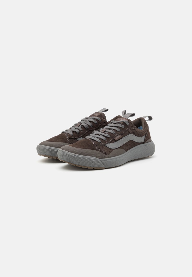 Zapatillas de ante marrón con acentos de textil gris, que cuentan con una suela de goma texturizada y cordones grises. Incluyen pestañas de agarre en el talón.