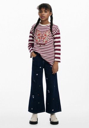 Gestreiftes langärmliges Oberteil in Burgunderrot und Weiß mit einem Pailletten-Schmetterlingsdesign, kombiniert mit weit geschnittenen Jeans aus Denim mit floralem Stickmuster.