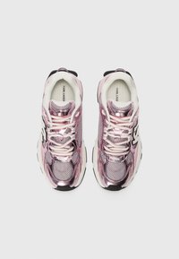 Pink metallic sneakers with mesh panels, white laces, and black accents. Features cushioned sole and brand logo on the tongue.