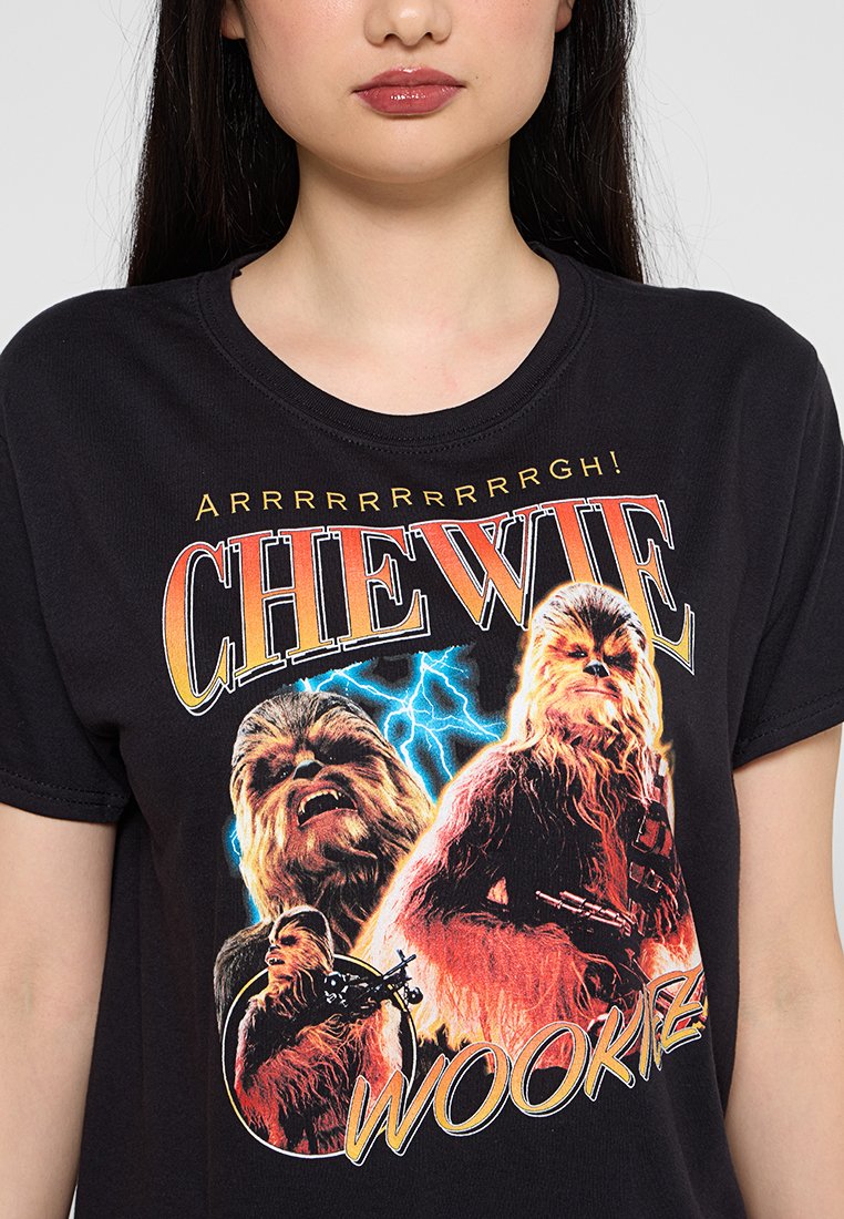 Schwarzes Baumwoll-T-Shirt mit einem Grafikdruck von Chewbacca, versehen mit fettem Text "CHEWIE" und lebendigen Farben, hauptsächlich Gelb und Orange.