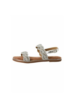 Sandales argentées tressées avec une bride de cheville ajustable et une semelle beige. La tige présente une texture à motifs et un design plat.