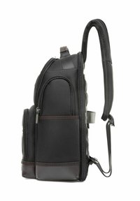 Czarny plecak z teksturowanym wykończeniem, wieloma zamykanymi na zamek kieszeniami, wyściełanym panelem tylnym i regulowanymi paskami na ramiona. Wykonany z trwałego materiału.
