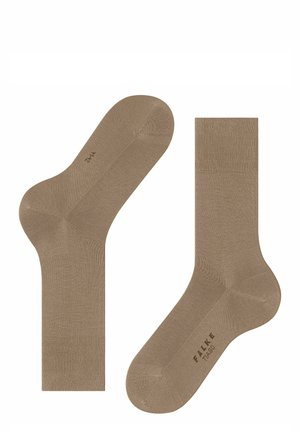 Chaussettes crew beiges fabriquées dans un matériau lisse et élastique. Elles présentent un revers côtelé et un pied sans couture pour un confort optimal. Logo de la marque imprimé sur le côté.