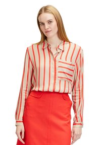 Cream blouse with red vertical stripes, long sleeves, and a button-up collar; features a front pocket. Paired with a red skirt.