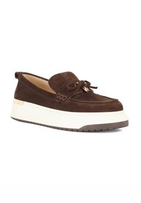 Brown suede slip-on shoe with a rounded toe, white platform sole, top bow detail, and textured accents on the upper.