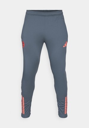 Pantalons de sport gris avec une taille élastique, des poches latérales et des accents rose en trois bandes sur les jambes. Présente un logo rond sur la cuisse gauche.