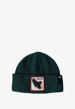 Cappello in maglia di colore verde scuro con trama a costine, caratterizzato da un distintivo in evidenza che mostra un'aquila e la parola "LIBERTÀ" in blu.