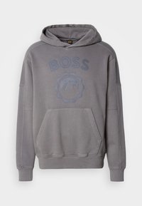 Hanorac gri cu o buzunar frontal tip kangaroo, un logo mare "BOSS" și un design montan. Fabricat dintr-un material moale, cu manșete și tiv dintr-o țesătură cu nervuri.