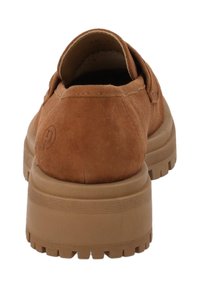 Bruine suede instapper met dikke rubberen zool en gegroefde loopconstructie, gezien vanaf de achterkant.