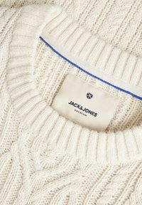 Cream cable-knit sweater featuring a ribbed neckline and a blue accent band. Label reads "JACK & JONES PREMIUM" with a logo.