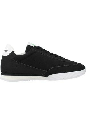 Baskets de sport noires en toile avec un design à profil bas, une semelle blanche et une subtile touche de vert sur la languette. Elles disposent de lacets ronds et d'une tige texturée.