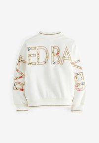 Weißes Sweatshirt mit geripptem Kragen und Bündchen. "ED BAKER" in großen, blumenmusterartigen Buchstaben auf dem Rücken und dem Ärmel, umrandet in Gold.