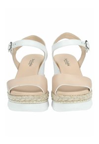 Sandales compensées blanches et beiges avec une semelle en corde tissée, des brides en cuir lisse, une boucle à la cheville et un design à bout arrondi.