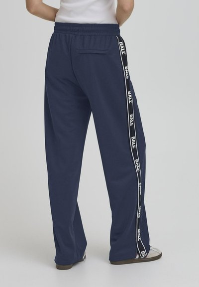 Pantalons décontractés en tissu doux de couleur marine, avec des rayures blanches portant le texte "BALL" sur les côtés et une taille élastique.
