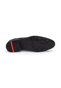 Suola di scarpa nera con motivo testurizzato, dotata di una striscia accentata rossa. Il materiale sembra gomma, progettato per la presa e la stabilità.