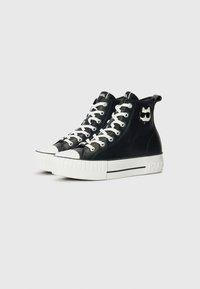 Black high-top sneakers with white laces, rubber toe caps, and a thick white sole. Features a cat logo on the side. Smooth leather texture.