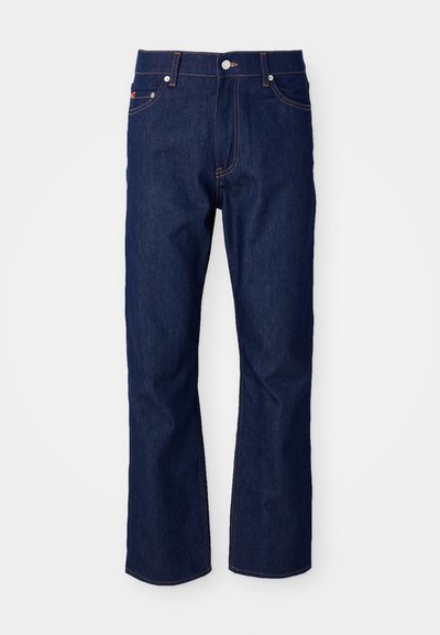 Jeans de mezclilla azul oscuro con un corte recto. Las características incluyen cinco bolsillos, costuras naranjas y un cierre de botón metálico en la cinturilla.