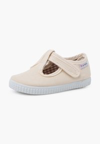 Scarpa in tela beige con suola in gomma bianca texturizzata, caratterizzata da un design con fasce incrociate e rivestimento a scacchi. Accompagnata da un piccolo logo colorato.