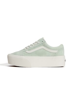 Baskets basses en daim vert clair avec bande latérale blanche ondulée, semelle plateforme blanche épaisse et lacets blancs sur fond blanc uni.