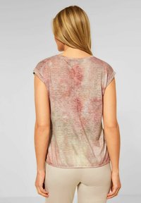 Krátký rukáv top s vybledlým růžovým a béžovým tie-dye vzorem, kulatým výstřihem a uvolněným střihem s kulatým lemem.