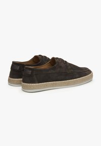 Tmavé semišové tenisky s kulatou špičkou, šněrovacím designem a přírodní jute podešví. Obsahují hnědou koženou akcentaci na patě.