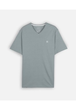 T-shirt uni bleu clair à manches courtes et col en V, avec un petit logo blanc sur la poitrine gauche et une étiquette près de l'ourlet inférieur.