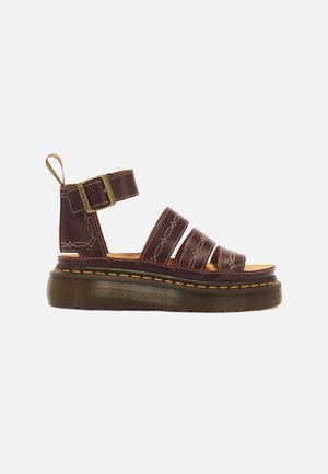 Mørkebrun læder platformsandal med ankelrem, messing spænde, gul syning og tyk rillede sål.