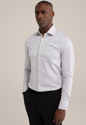 Cămașă gri deschis cu un model subtil cu dungi, mâneci lungi, guler cu nasturi și nasturi albi, combinată cu pantaloni negri.