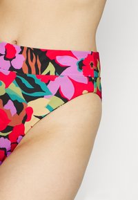Blomstrete bikini-bunn med høy midje-design. Har et livlig mønster av rosa, rødt, lilla og grønt på en svart bakgrunn.
