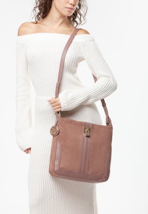 Borsa a mano in suede marrone con tracolla in pelle lucida rosa e dettagli in oro. Caratterizzata da un design a strisce verticali e un ciondolo circolare.