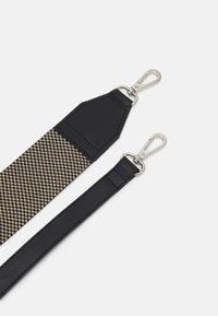 Sangle ajustable avec une partie supérieure en cuir noir et une section en tissu à motifs beige et noir, dotée de clips métalliques argentés aux deux extrémités.
