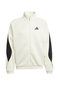 Veste blanche zippée avec des accents noirs sur les côtés, col montant, poignets côtelés et ourlet élastique. Présente un logo Adidas sur la poitrine.