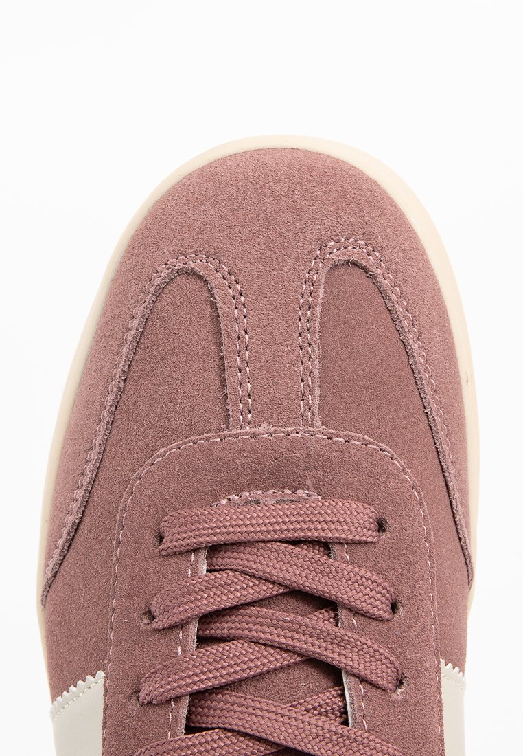Scarpa con tomaia in suede rosa polveroso, cuciture tonali e dettagli in crema. Punta arrotondata e design con allacciatura frontale.