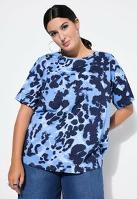 Modr�á oversized tričko s námořnickým abstraktním vzorem. Vyrobeno z lehkého materiálu s kulatým výstřihem a krátkými rukávy.