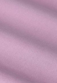 Tissu rose avec une texture lisse, présentant un léger éclat. Le matériau montre des variations légères de ton, indiquant une qualité douce et malléable.