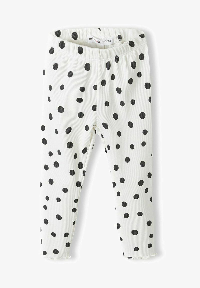 Bela rebrasta legging z vzorcem črnih pikic, z raztegljivim pasom in raztrganim robom pri gležnju.