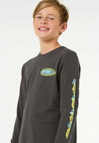 Langarmshirt in Dunkelgrau aus Baumwolle, mit einem runden Logo auf der Brust und bunten Designs an der linken Ärmelseite.