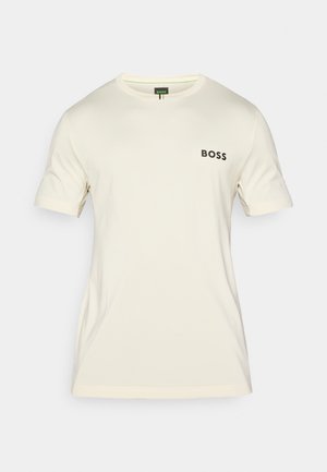 T-shirt de manga curta creme, feita de tecido suave, com um decote redondo e o logótipo preto "BOSS" no lado esquerdo do peito.