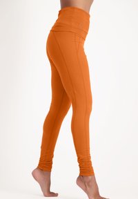 Oranga högmidjade leggings gjorda av stretchy tyg med sömdetaljer, slim fit och en mjuk yta, designade för enkel rörelse.
