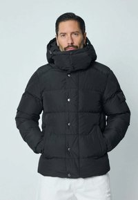 Doudoune noire avec capuche, dotée d'un design matelassé, de grands boutons à l'avant et de poches latérales. Fabriquée en tissu lisse et léger.