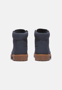 Stivaletti alla caviglia in suede blu navy con punta tonda e colletto imbottito, dotati di suola in gomma beige e cuciture rinforzate sul retro.