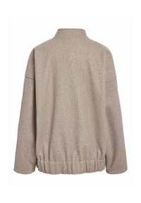 Veste en mélange de laine beige avec un col haut, des épaules tombantes et un ourlet élastiqué. Texture douce avec des coutures minimales et aucun hardware visible.