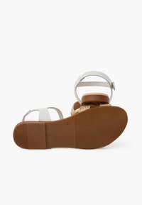 Białe sandały na paski z plecionym beżowym obcasem, brązową gumową podeszwą i regulowanym paskiem na kostkę. Rozmiar oznaczony jako 35 na podeszwie.