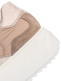 Nahaufnahme der Ferse eines beigen Sneakers, der strukturiertes Leder, Wildleder, Stoffeinsätze und eine dicke weiße Gummisohle mit profilierter Lauffläche zeigt.