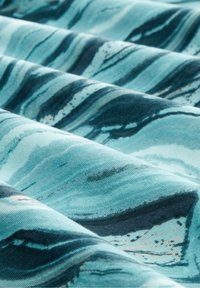 Tessuto blu e teal con un motivo marmorizzato a onde; texture liscia con accenti blu scuro e tonalità più chiare sottili.
