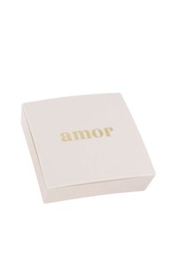 En kvadratisk, mjuk rosa låda med en glänsande yta; ordet "amor" tryckt i guld centrerat på toppen. Inga ytterligare mönster eller utsmyckningar.