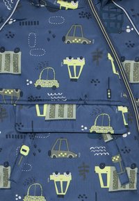 Marineblaue Kinderjacke mit einem verspielten Muster aus Autos und Verkehrssymbolen in Grün, Grau und Weiß. Glatte Textur, mit Reißverschluss.