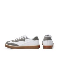 Weiße und graue Sneakers mit einem durchbrochenen Design, Wildlederakzenten und einer Gummisohle mit einem roten Detail an der Ferse.