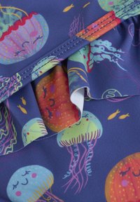 Blauer Stoff mit bunten Quallenmustern, akzentuiert mit gerafften Kanten, leuchtenden Farben und verspielten Designs.